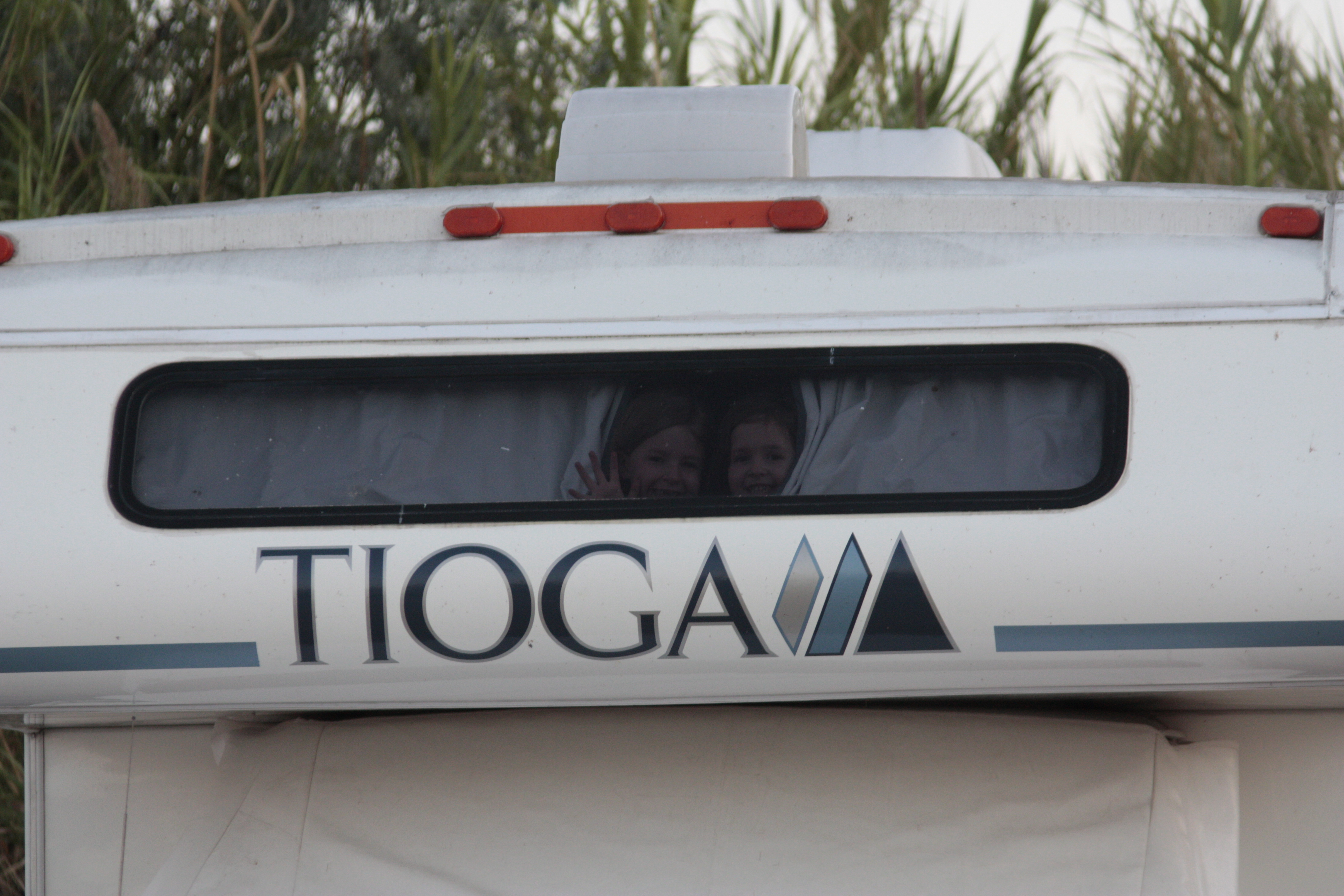 Children peeking from the Tioga's cabover window.
