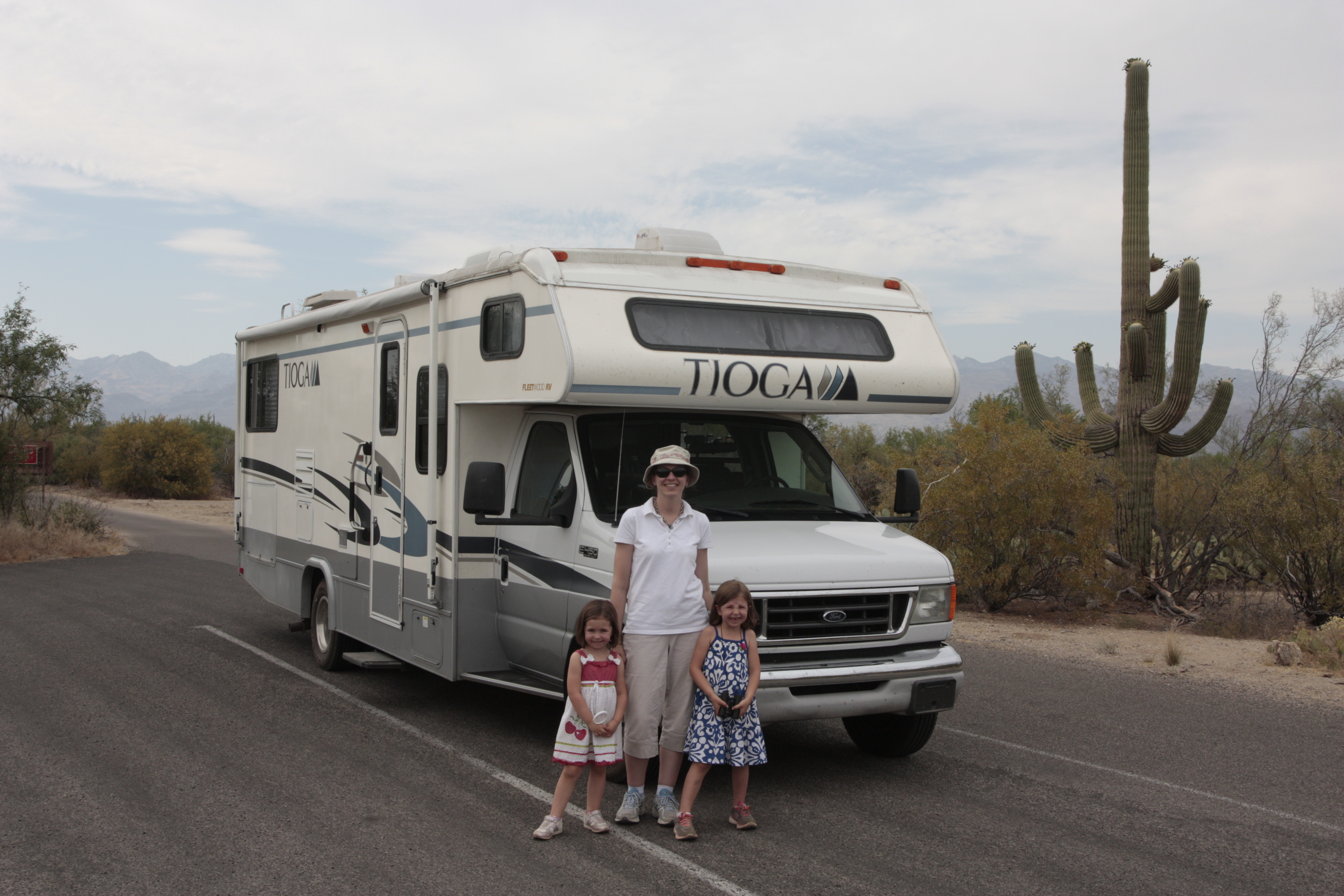 The Tioga parked in the desert with family standing out front.