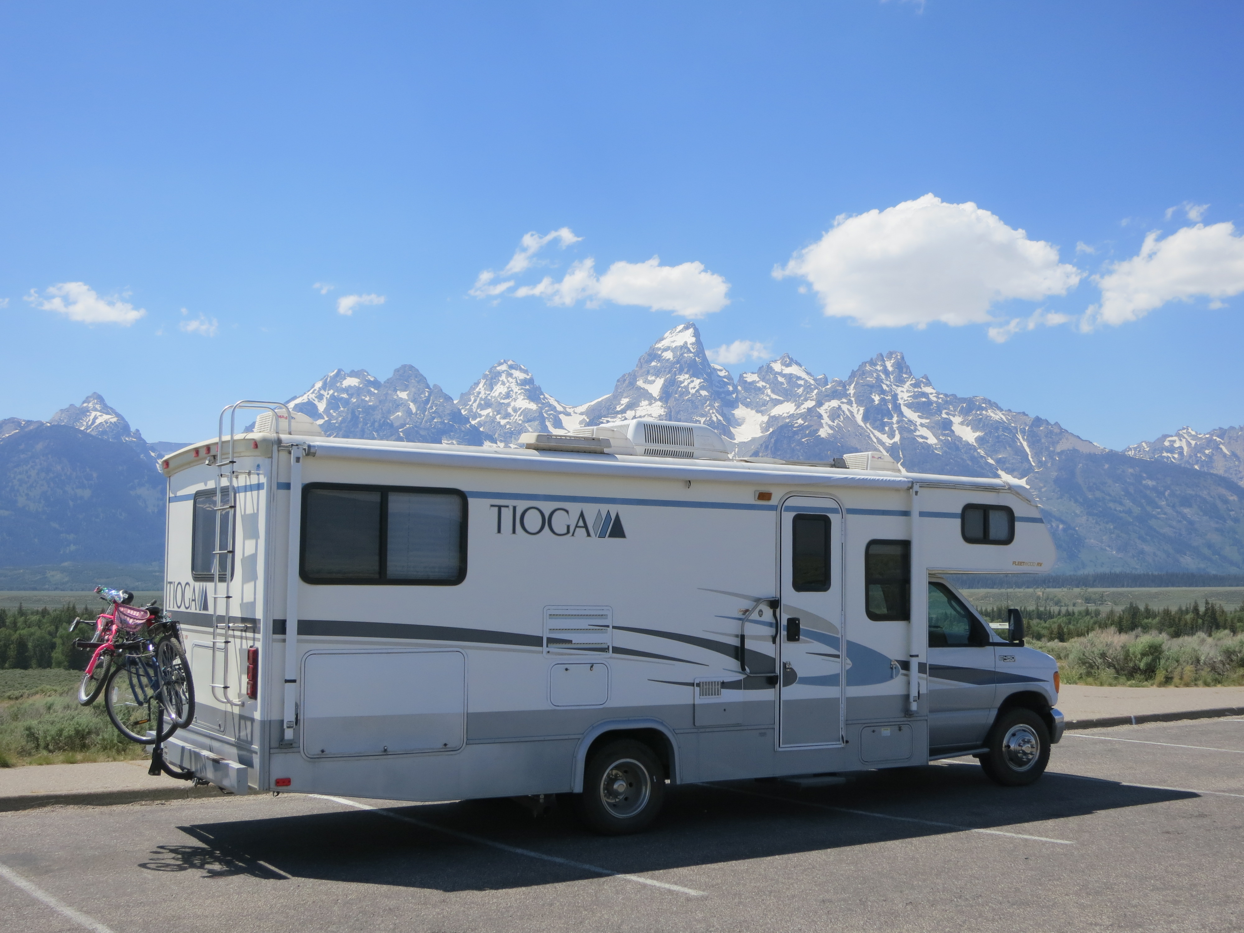 The Tioga parked with the Grand Tetons behind it.