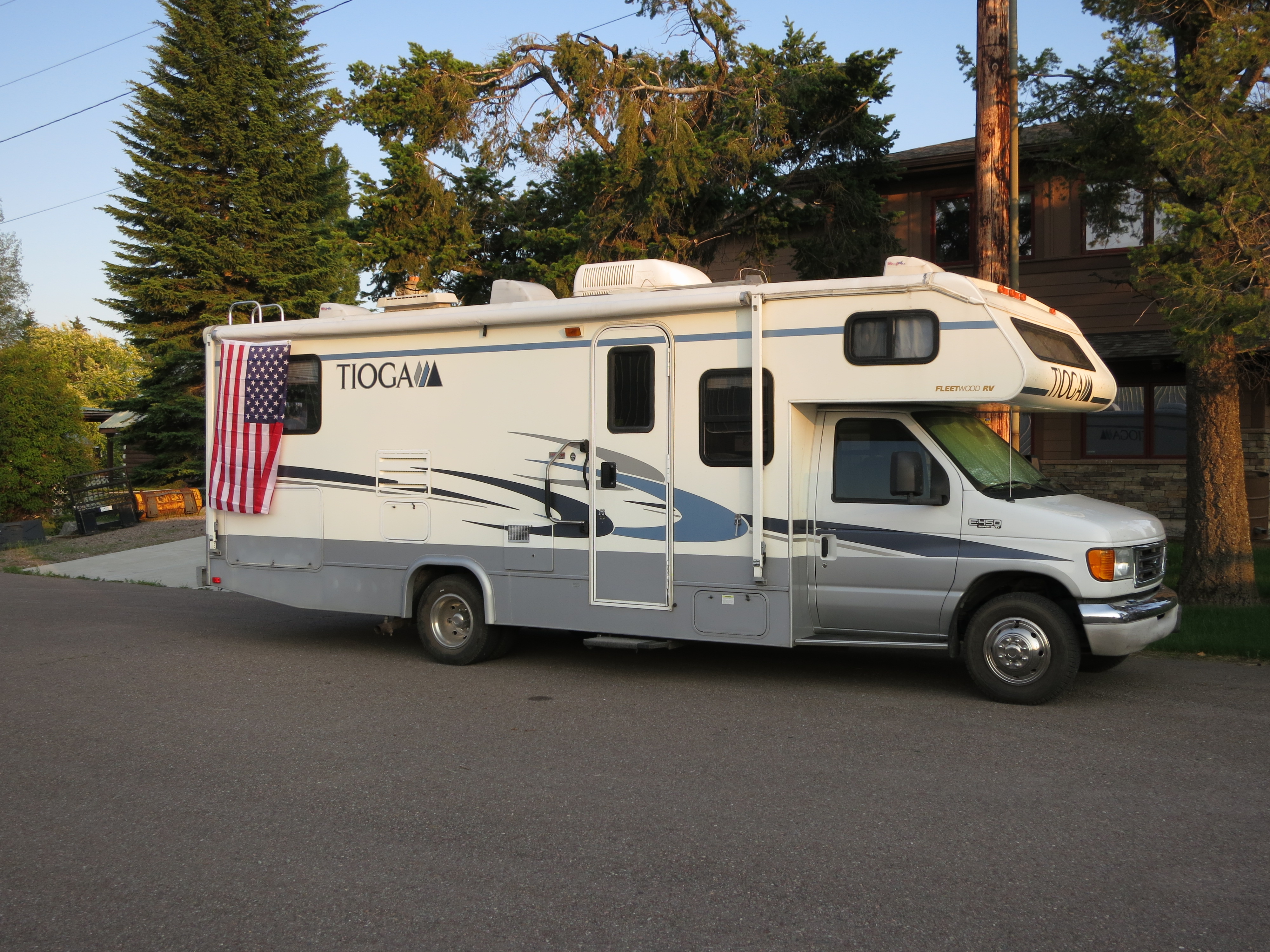 The Tioga parked in soft evening light with a flag nearby.