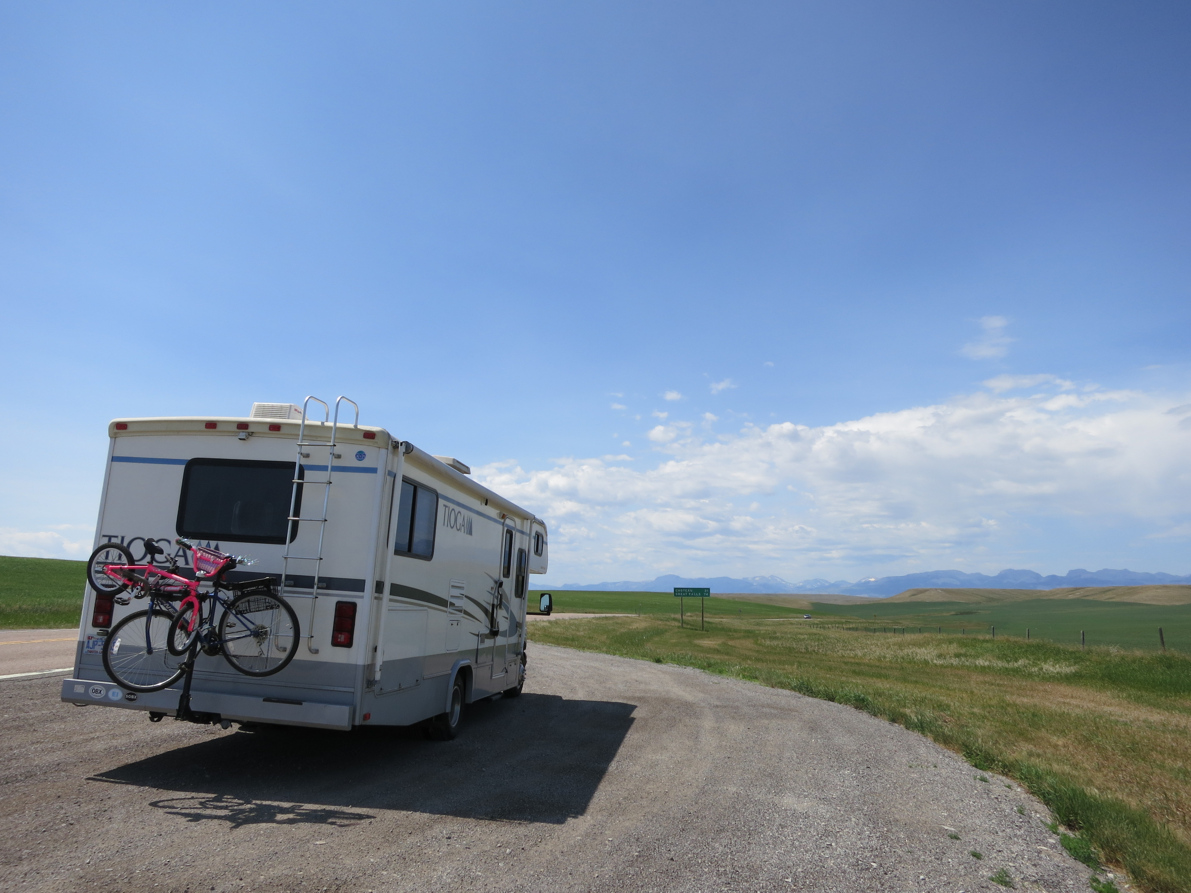 The Tioga parked beside an open western landscape with bikes on the back.
